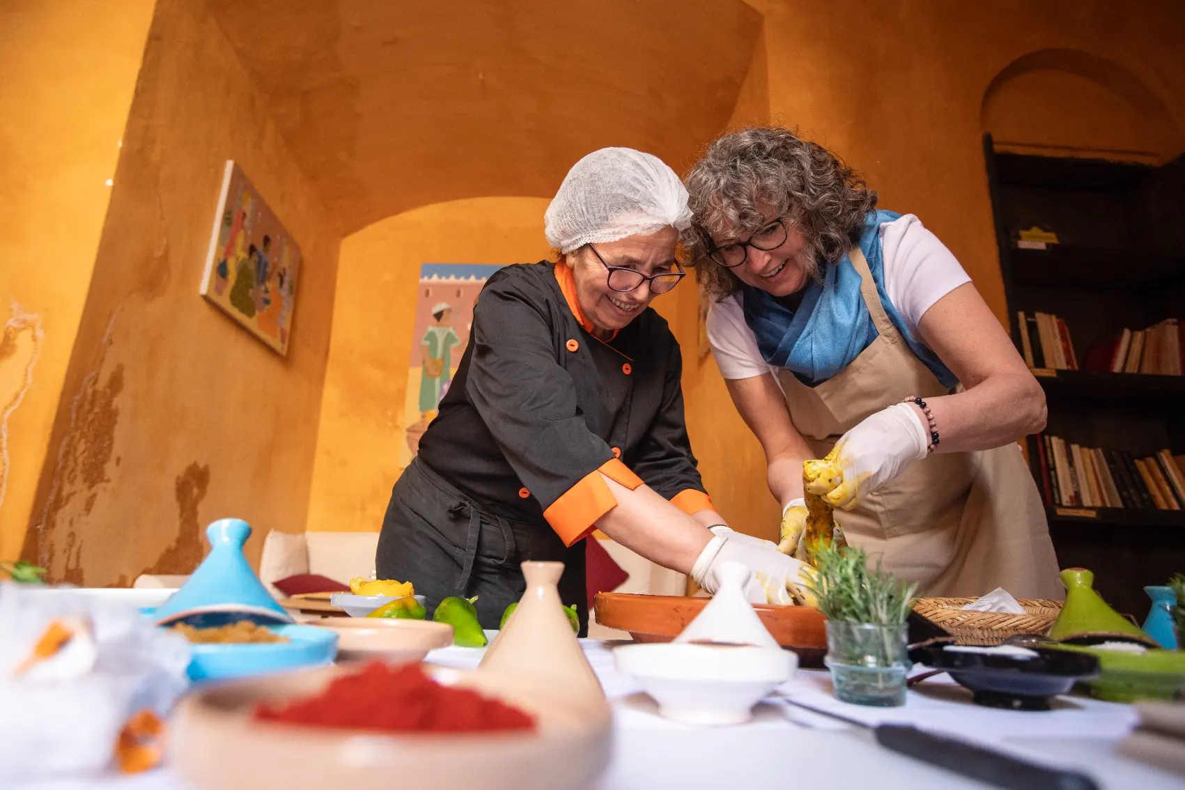 A female traveller and local cooking class host have fun together during a hands-on lesson