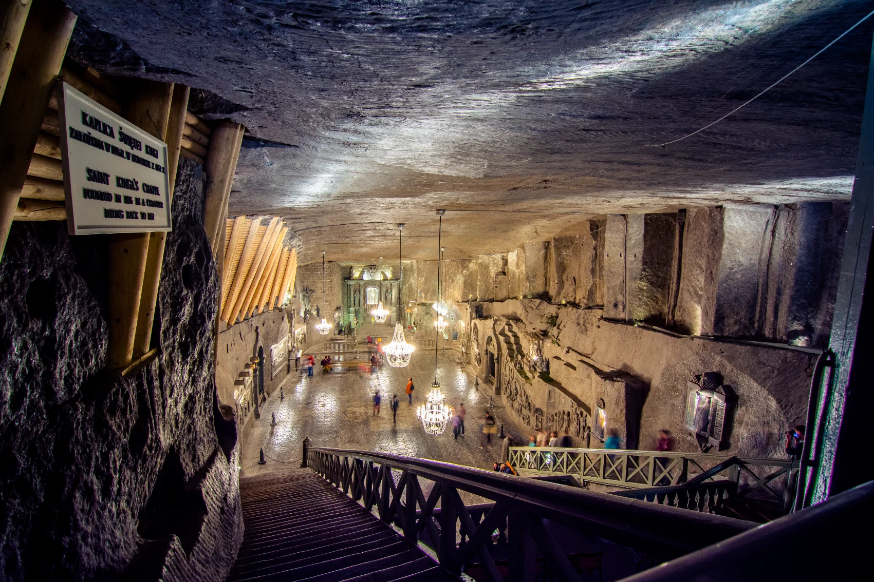 Wieliczka Salt Mine, Poland People walk in an illuminated underground space at Wieliczka Salt Mine, Poland