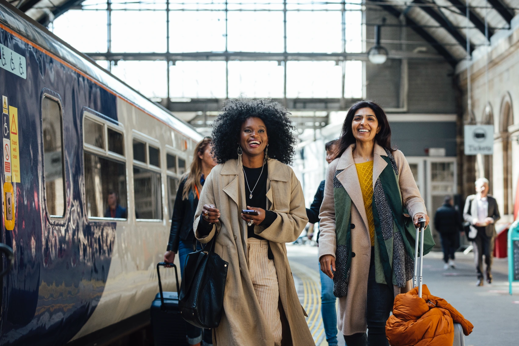 Packing lightly Two women travellers take their luggage through a train station