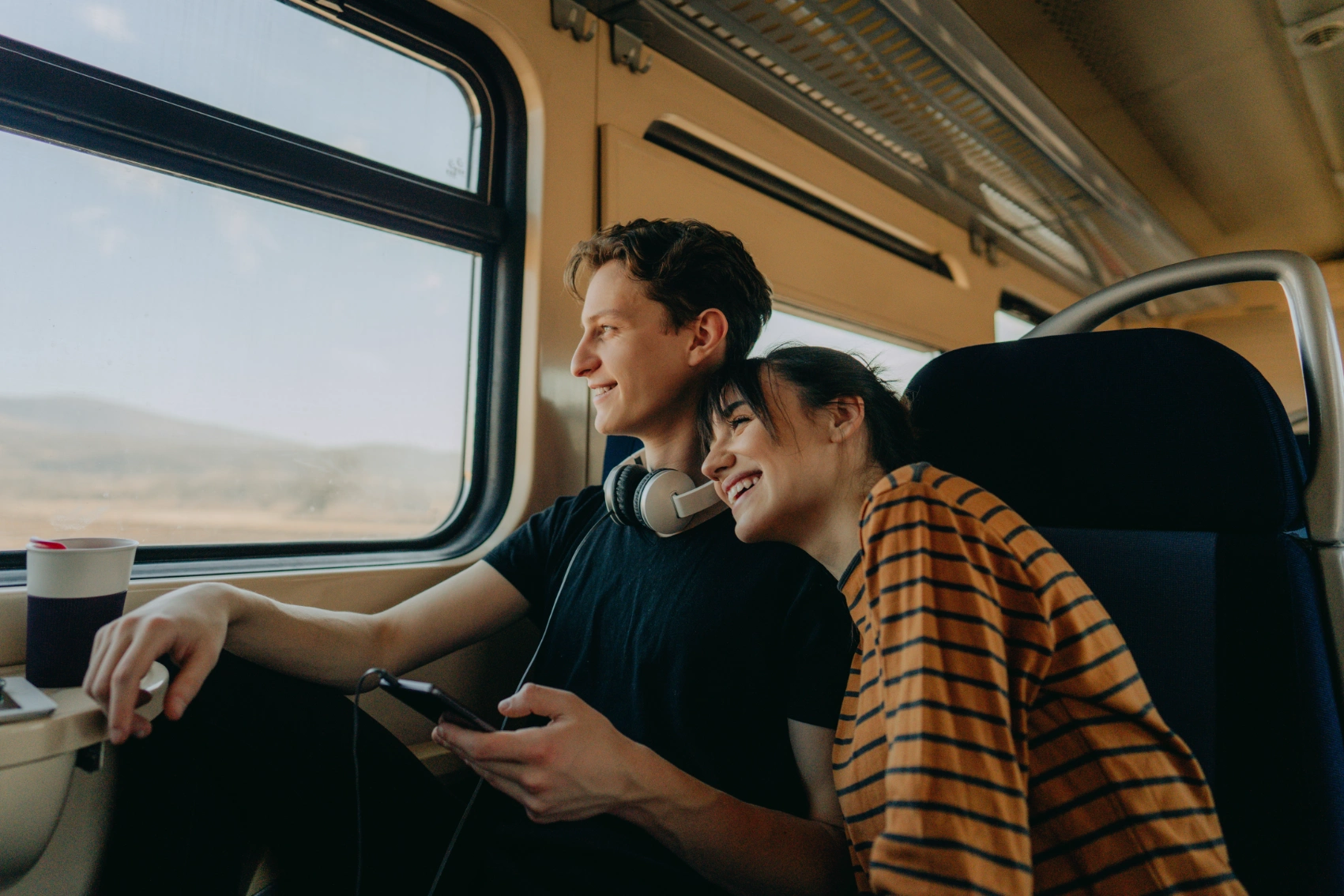 Train travel Two travellers look out the window while on a train trip