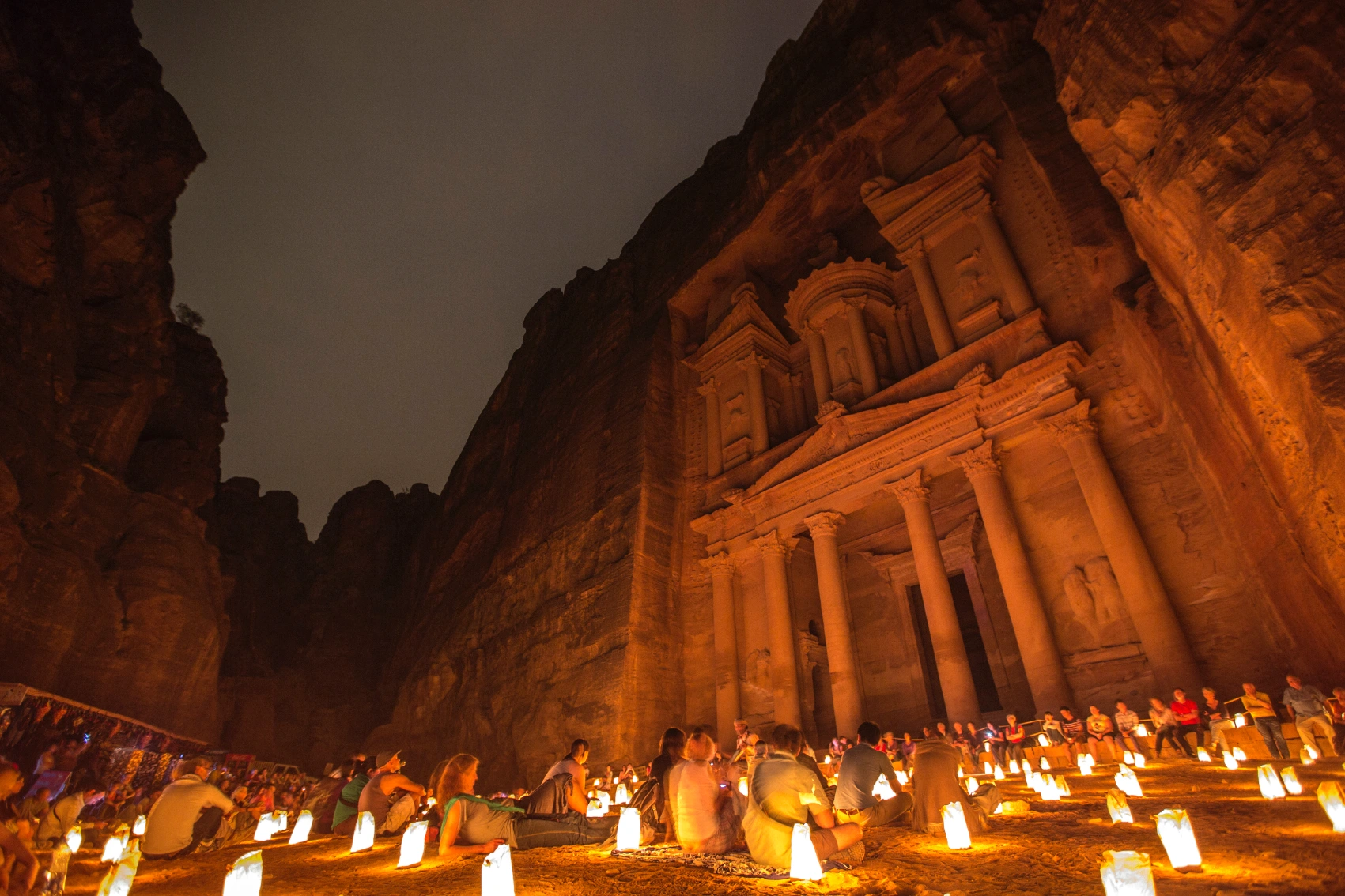 Petra by Night, Jordan Travellers sit in front of the candlelit Treasury at Petra, Jordan