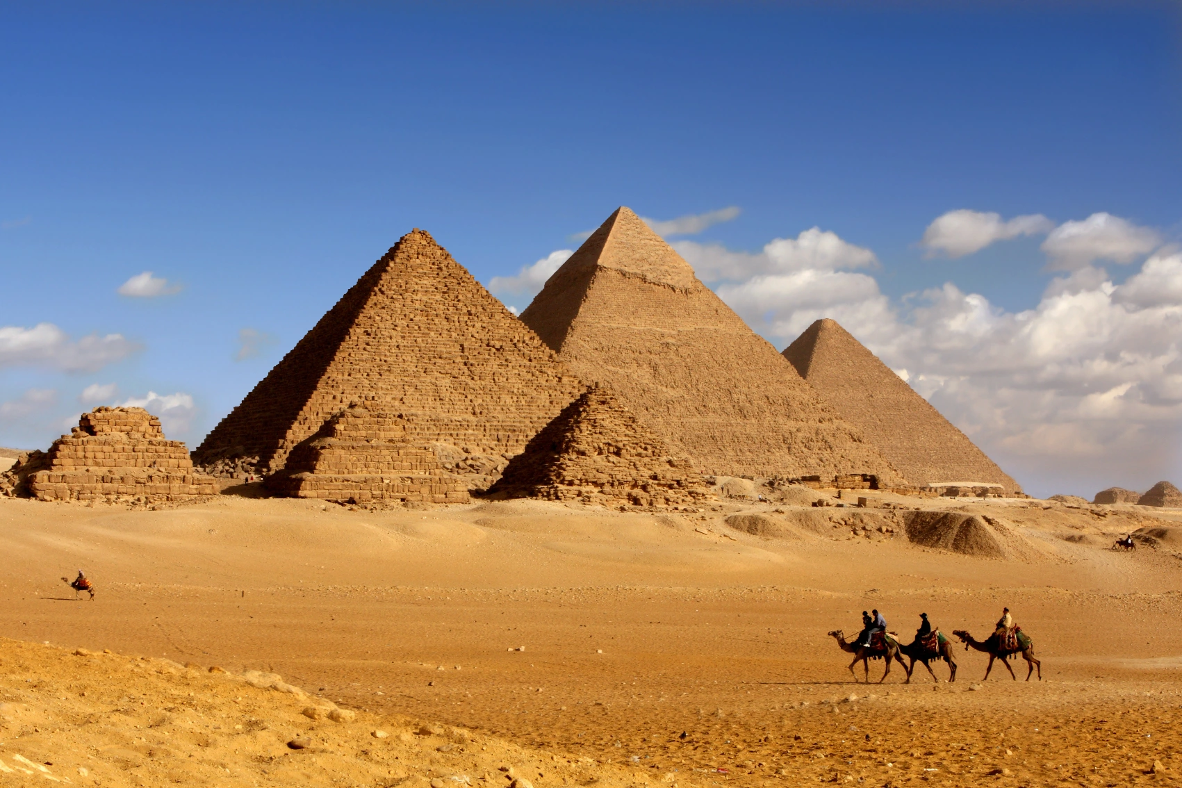 Pyramids of Giza, Egypt Riders on camels in front of the Pyramids of Giza in Egypt
