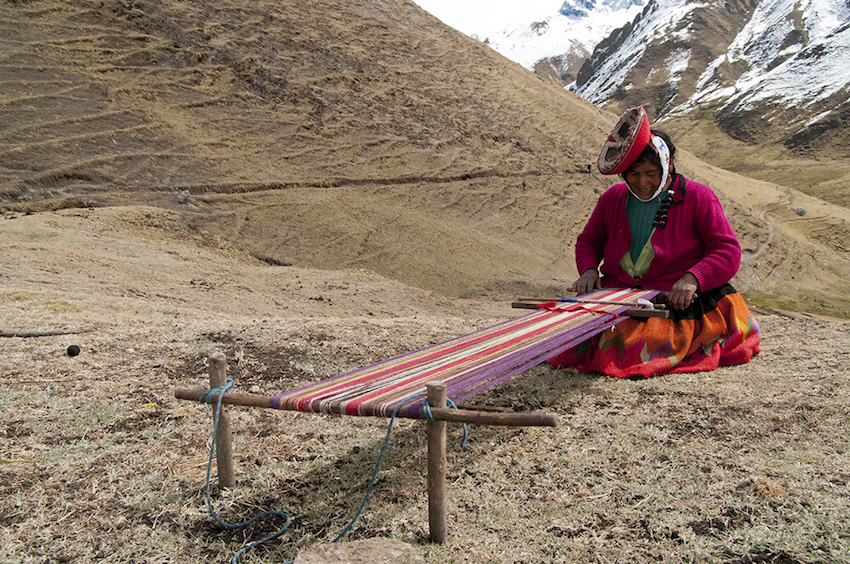 quechuan woman weaving on a loom outside.