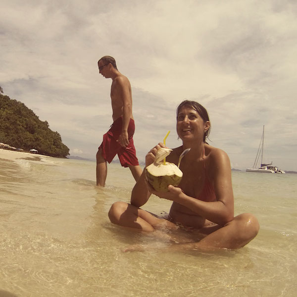 sititng in the water drinking a coconut