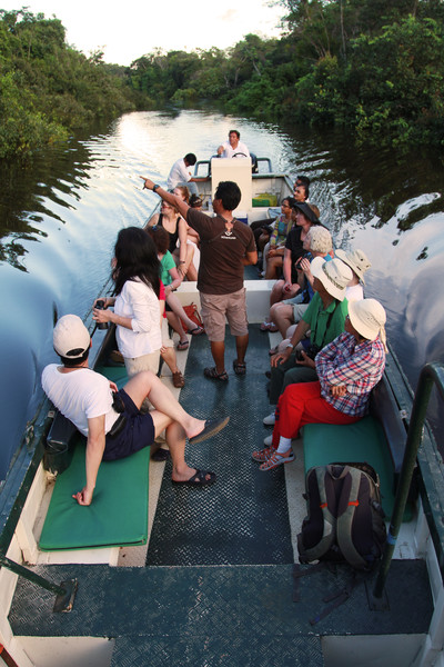 <p>Peru offers great learning opportunities for nature-loving kids and their parents.</p> boat trip on the amazon - people learning
