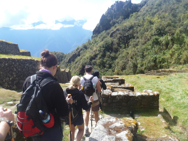<p>One foot in front of the other.</p> trekkers in a line walking down hill.