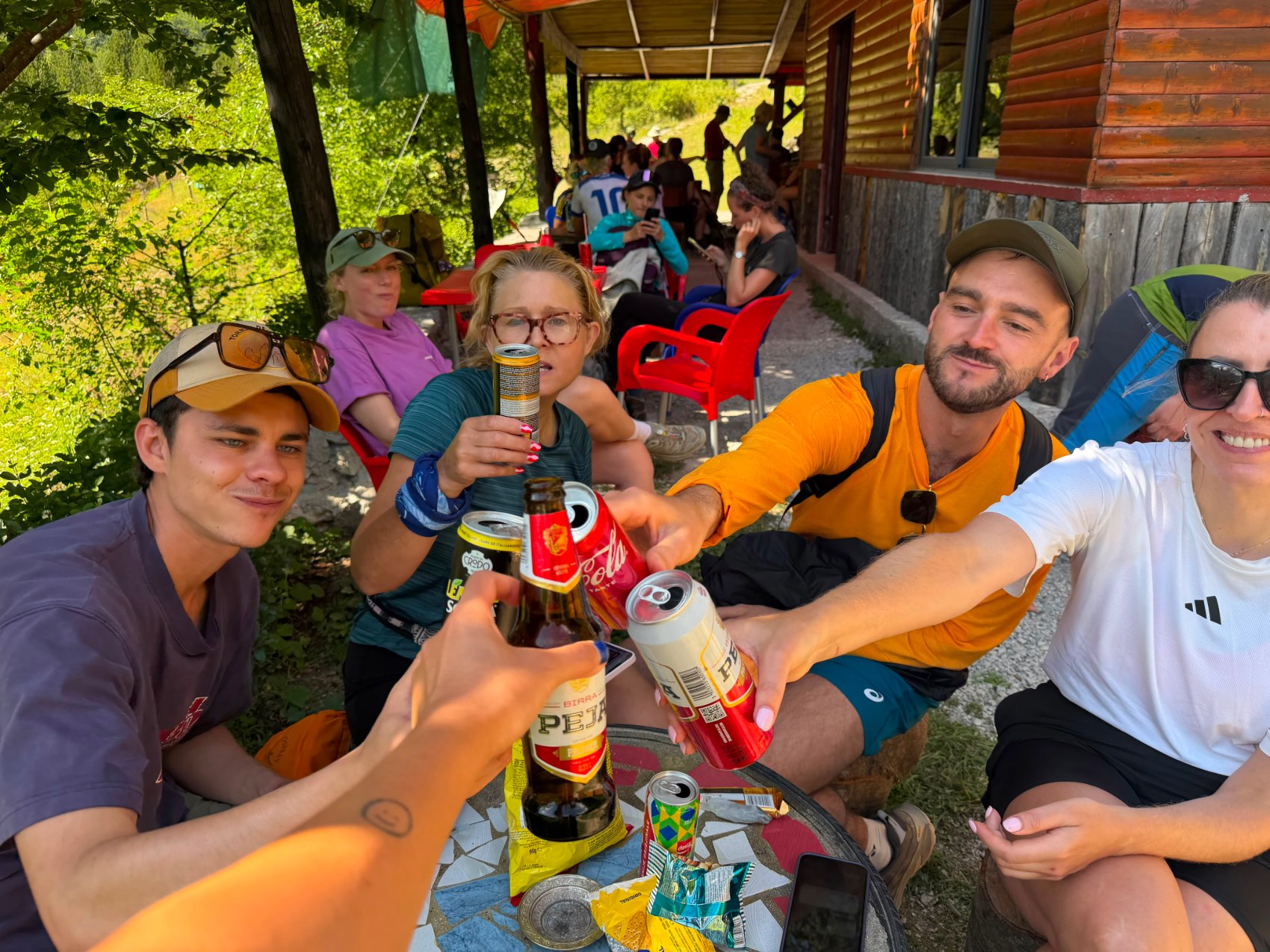 CEO Tom Leonard and other travellers cheersing with some beers in Albania