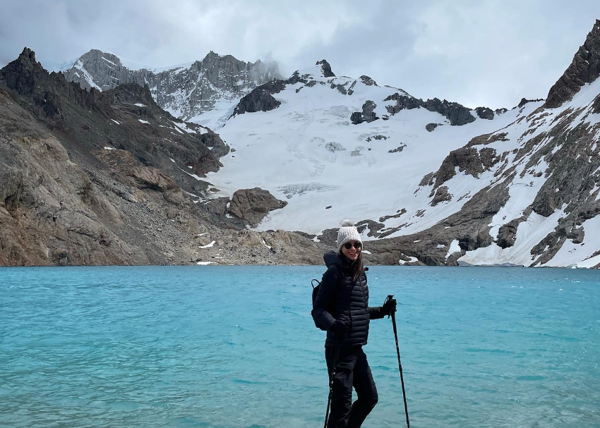 writer and traveler Jessica Moy stands in front of the legendary blue water lagoons and snow-capped peaks of Patagonia