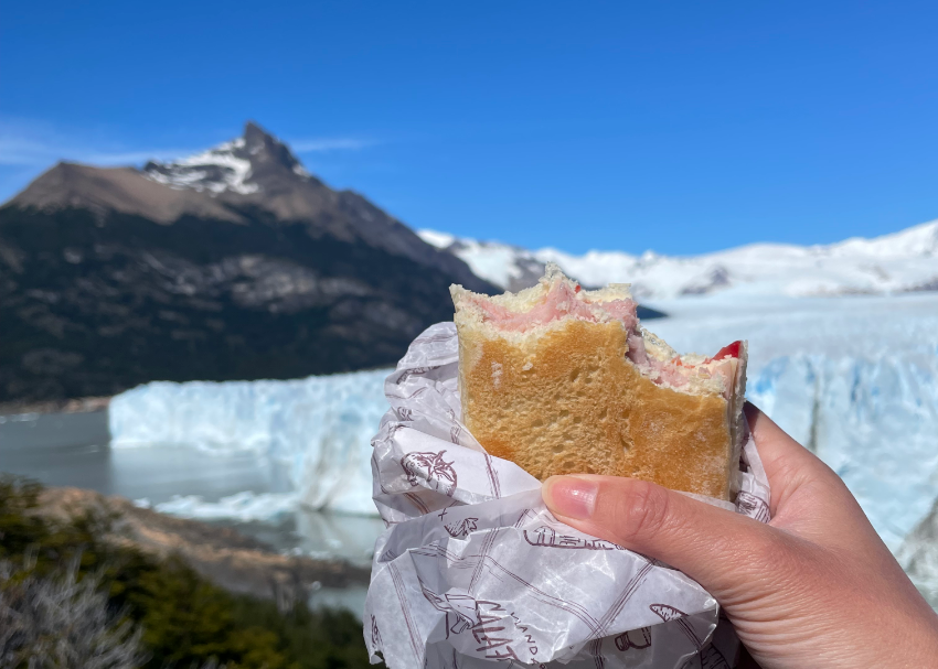 showing off a well-earned turkey sandwich with a view of the Perito Moreno Glacier