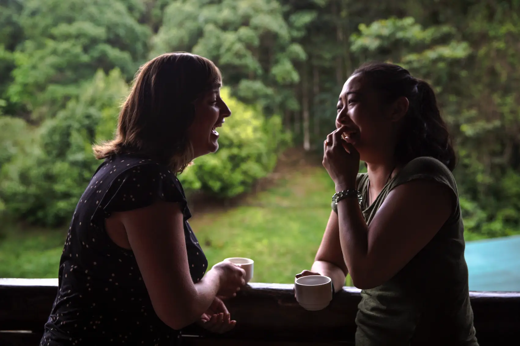 Costa Rica Coffee Chat Two solo travellers share a laugh over a cup of coffee at a community coffee farm in Costa Rica