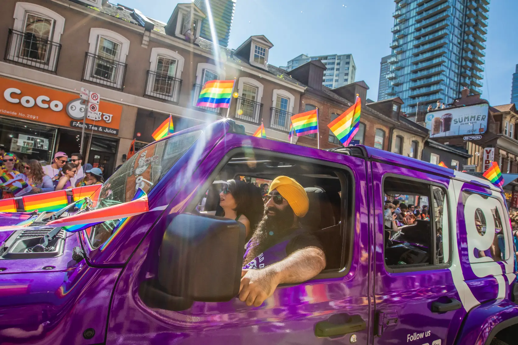 G Adventures staffers travel in an iconic purple Jeep during Pride Toronto