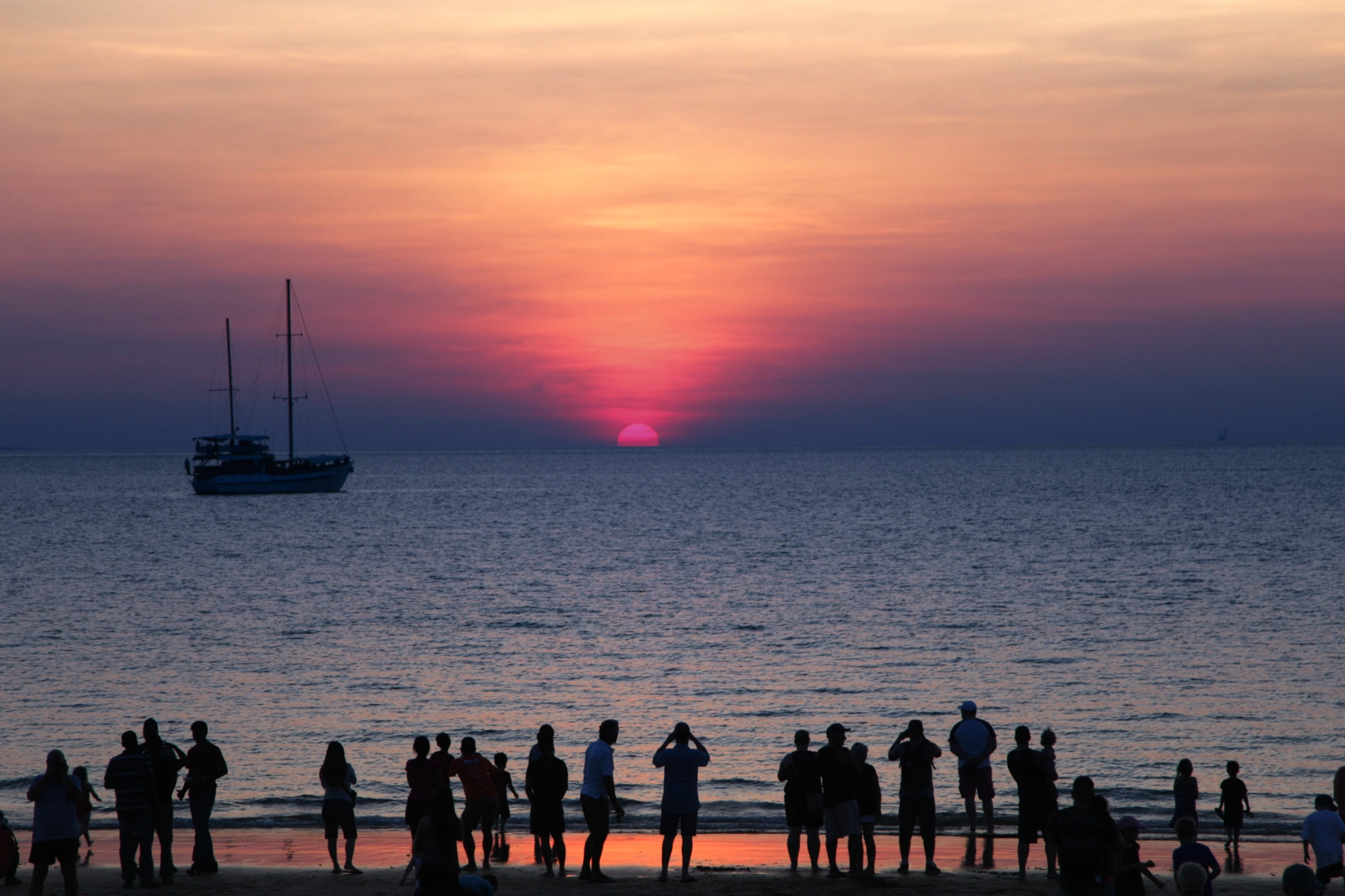 People gather on Mindil Beach to take photos of the sunset