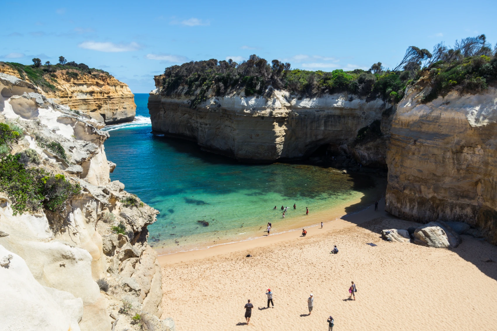 Visitors walk on the beach on a sunny day in Lord Ard Gorge on the Great Ocean Road