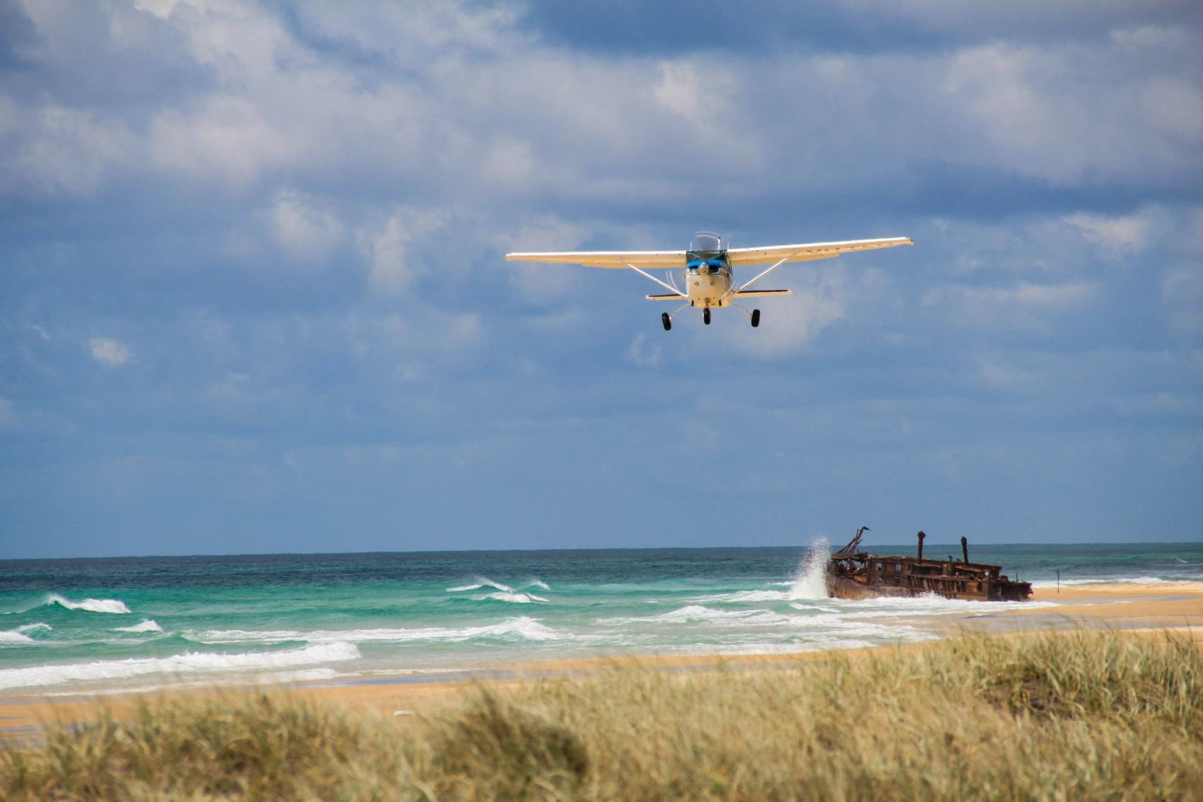 An airplane gets ready to land on 75 Mile Beach in K'gari