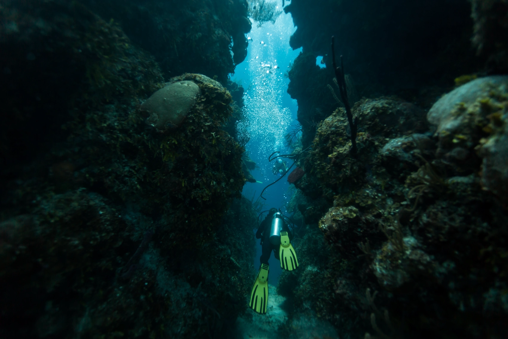 A scuba diver swims through a tunnel at the Blue Hole in Belize