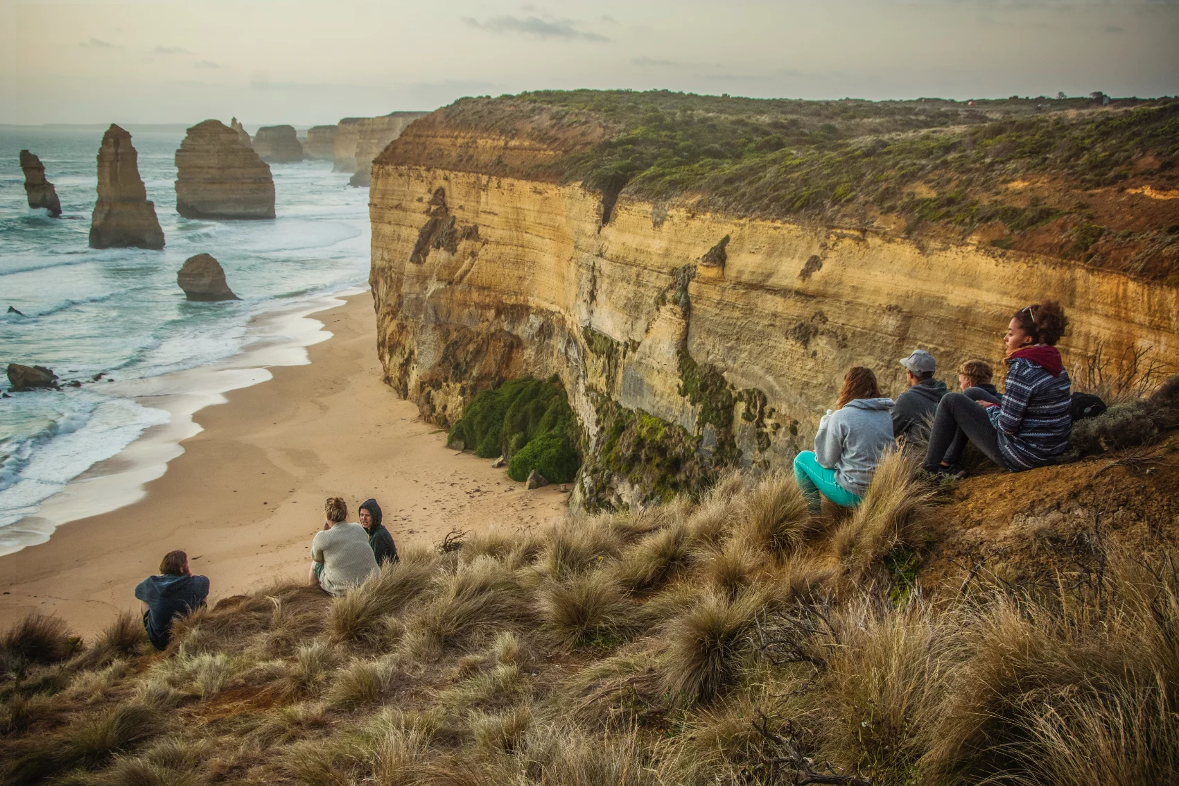 A group of travellers looks over the sea along the Great Ocean Road in Australia