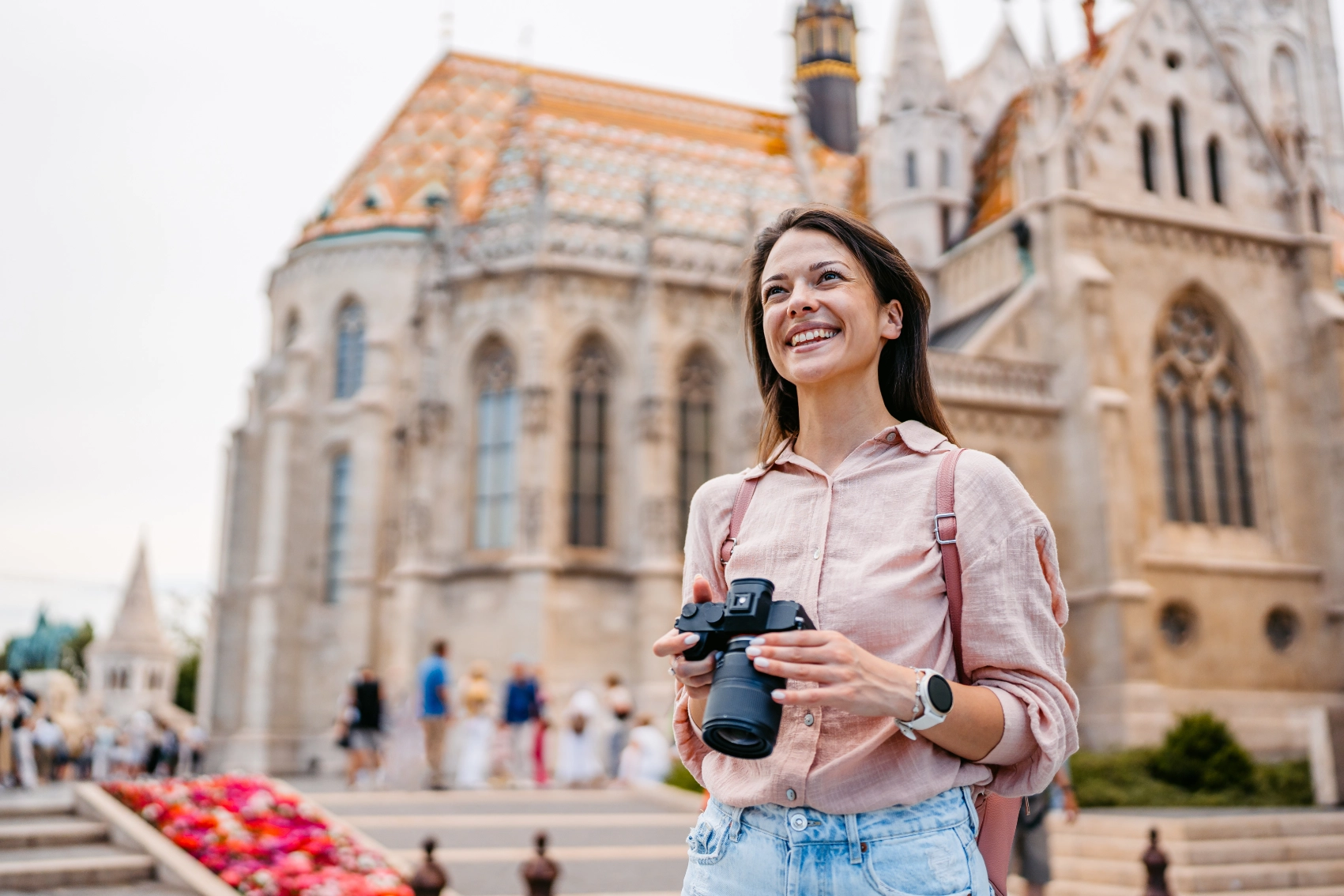 A woman traveller with a camera stands at Fisherman's Bastion in Budapest