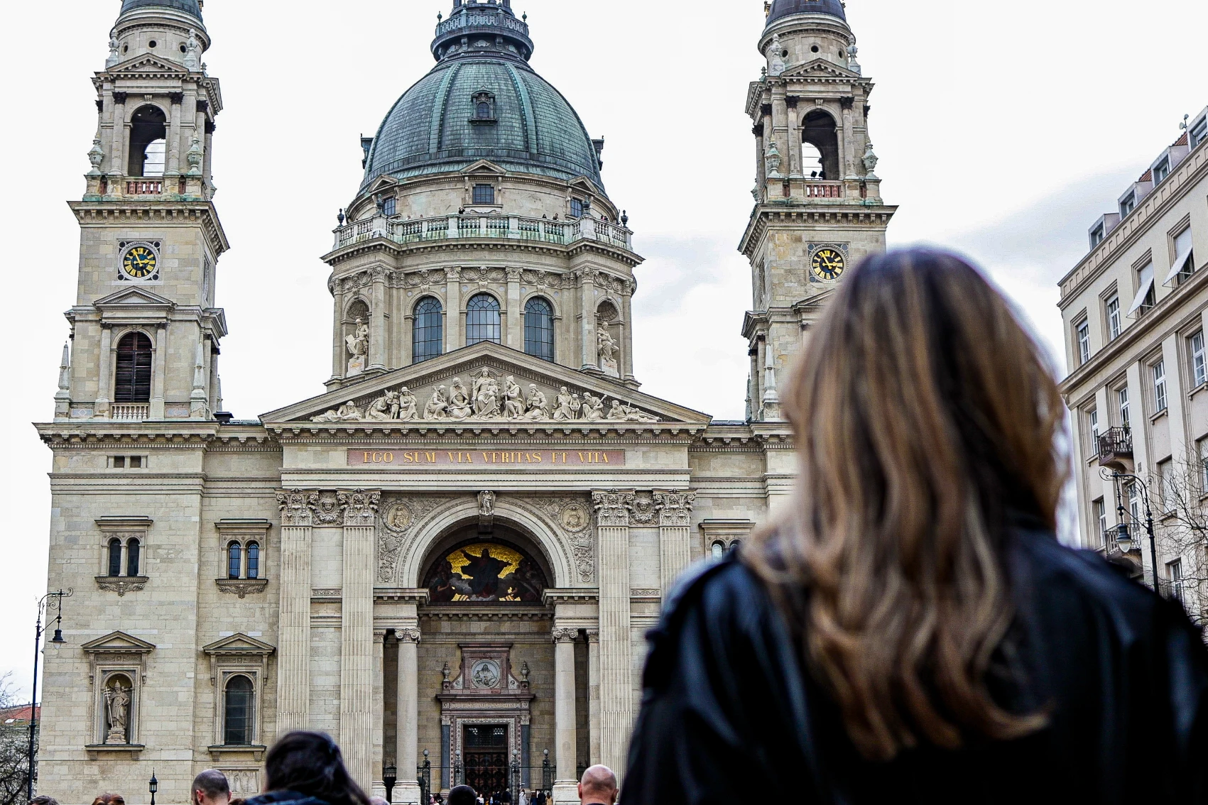 A woman stands in front of St. Stephen's Basilica in Budapest