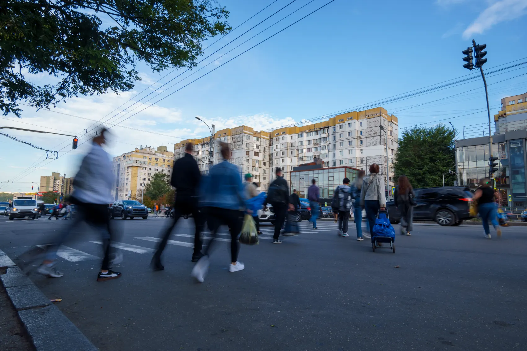 A buzz of blurry people cross the street through traffic in Chisinau