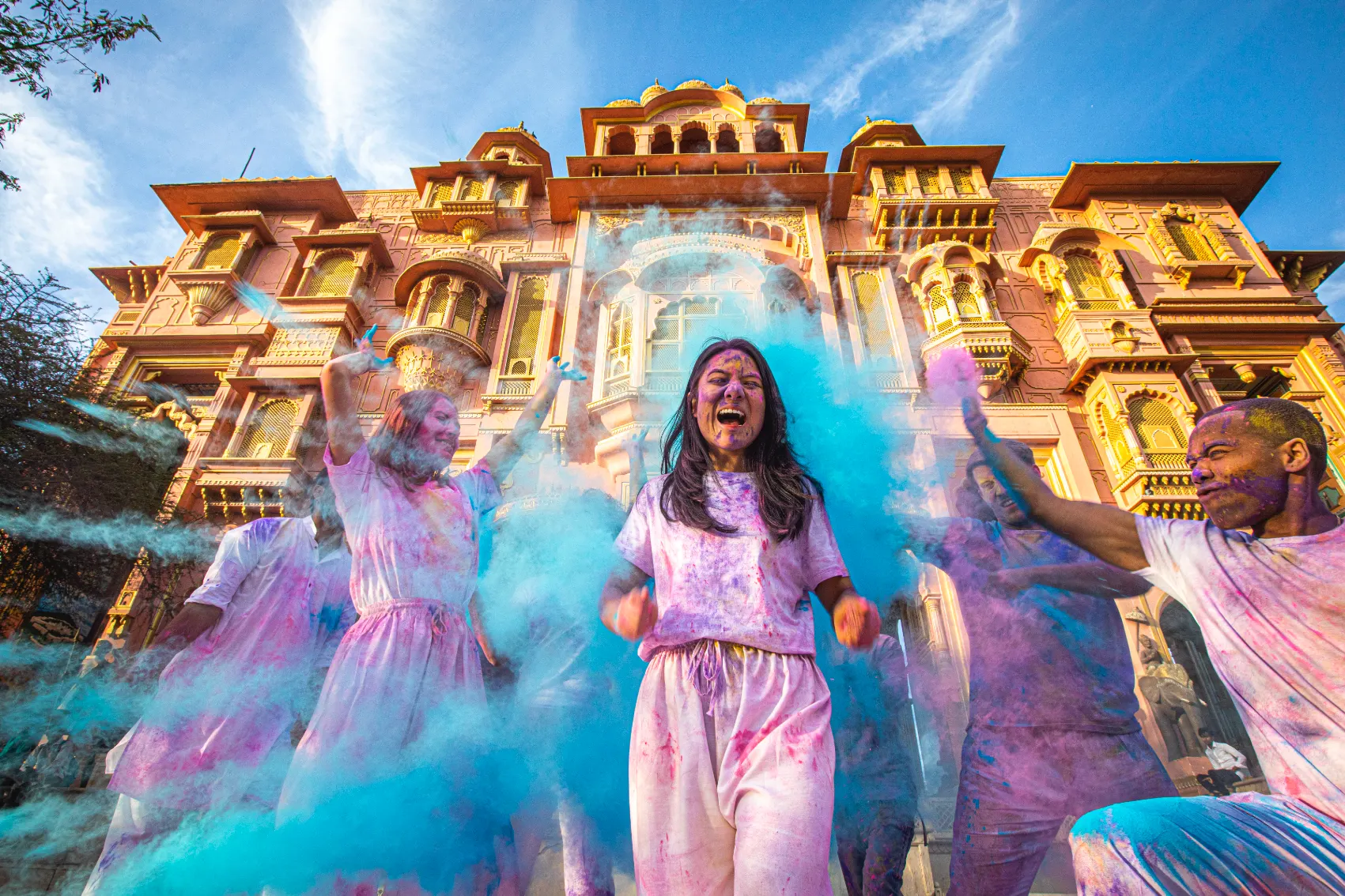 A bunch of rainbow-covered travellers celebrate as gulal is thrown in the air of radiant Jaipur during Holi