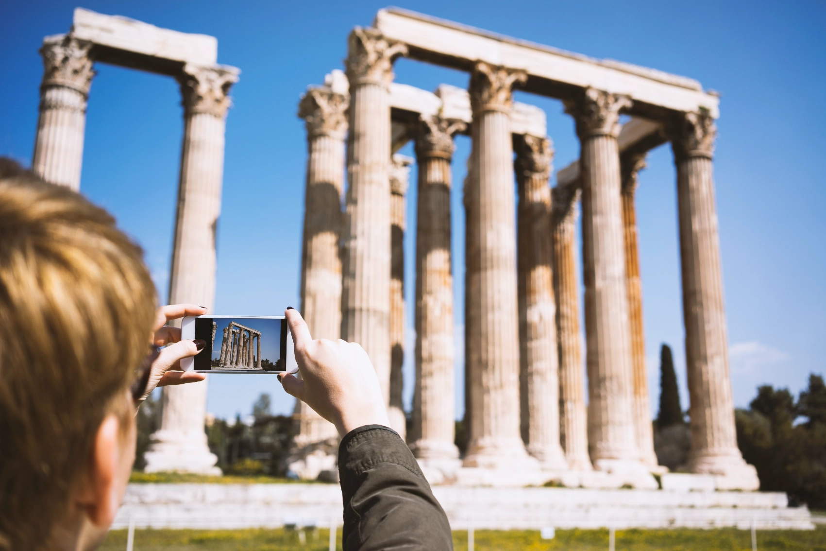 Temple of Olympian Zeus, Athens A traveller takes a photo of the Temple of Olympian Zeus in Athens, Greece