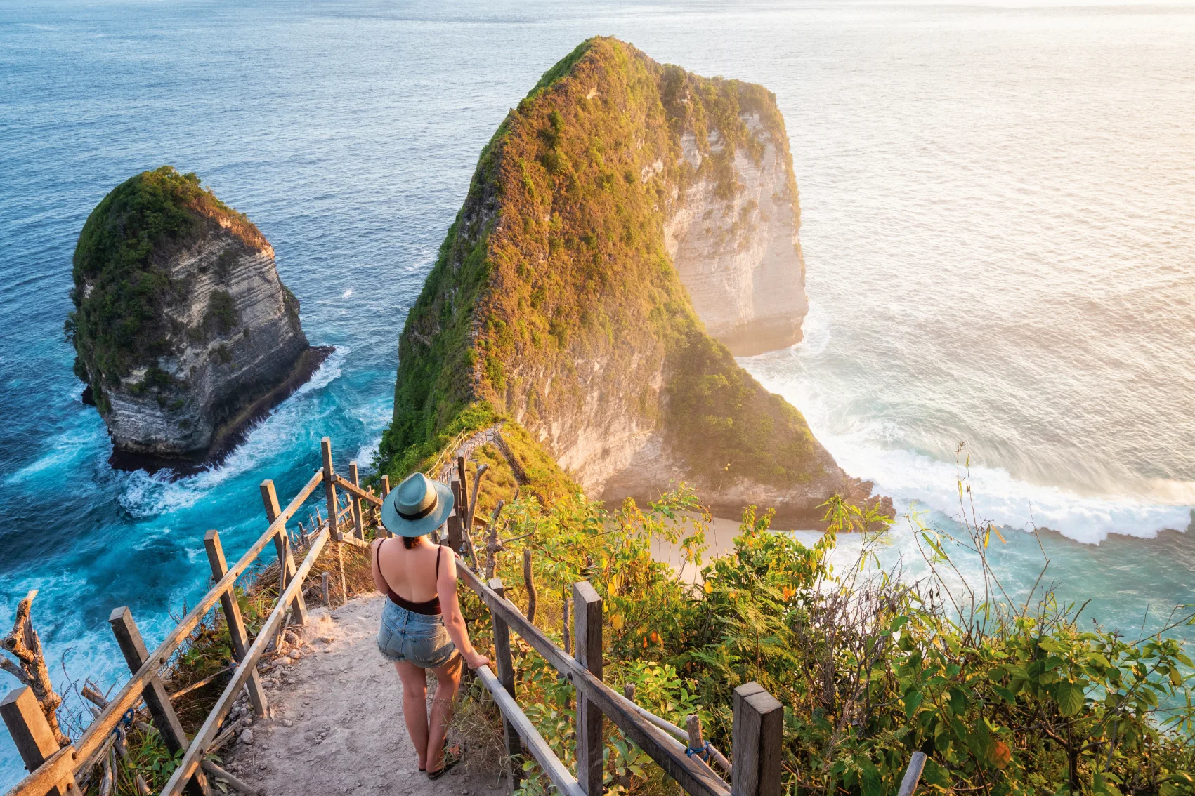 Kelingking Beach, Bali A woman stands on a steep path overlooking Kelingking Beach, Bali
