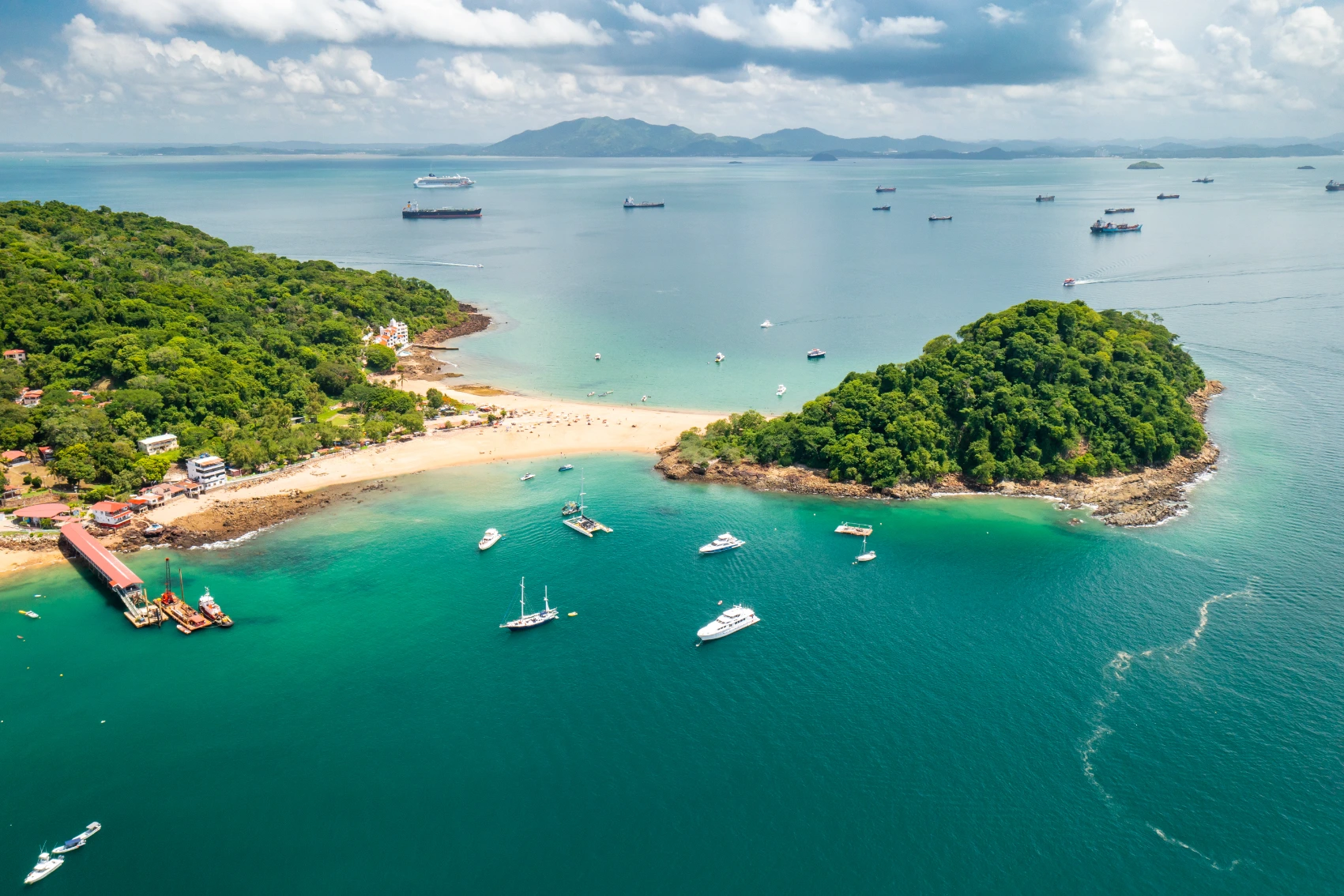 Aerial view of Taboga Island with huts along the seafront and boats in the water
