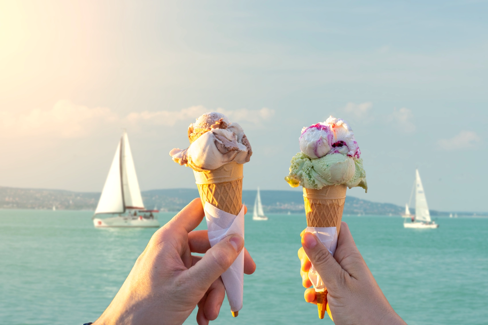 Lake Balaton, Hungary Two people hold up ice cream cones in front of Lake Balaton, Hungary
