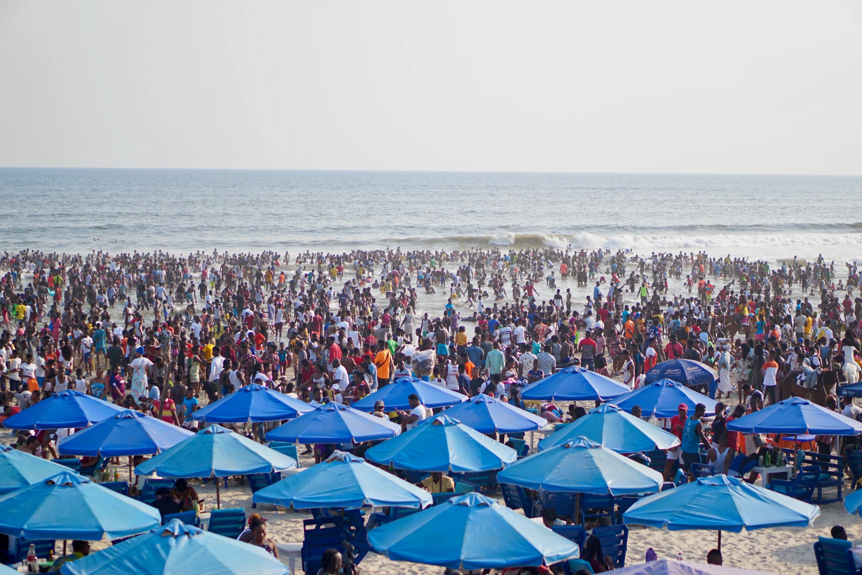 Labadi Beach, Ghana Crowds of people walk on the sand and in the water at Labadi Beach, Ghana