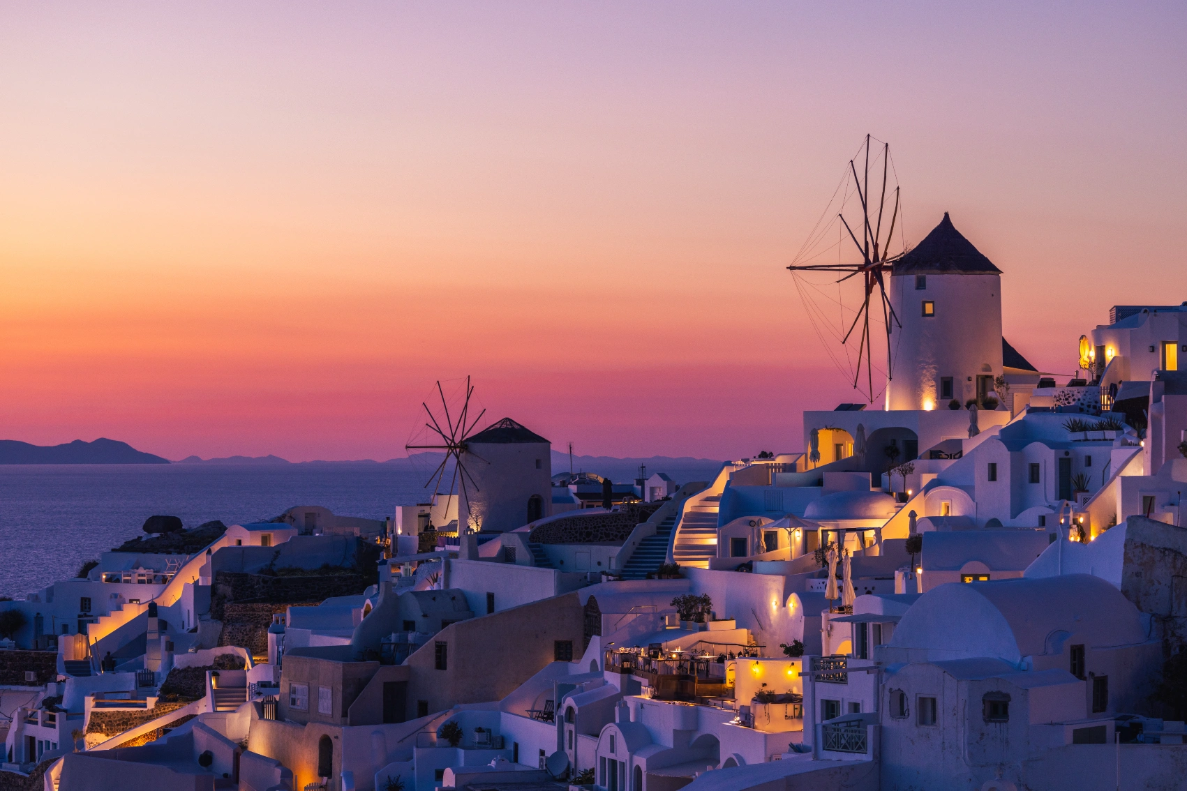 Sunset in Santorini, Greece Whitewashed buildings are silhouetted by a colourful sunset sky in Santorini, Greece