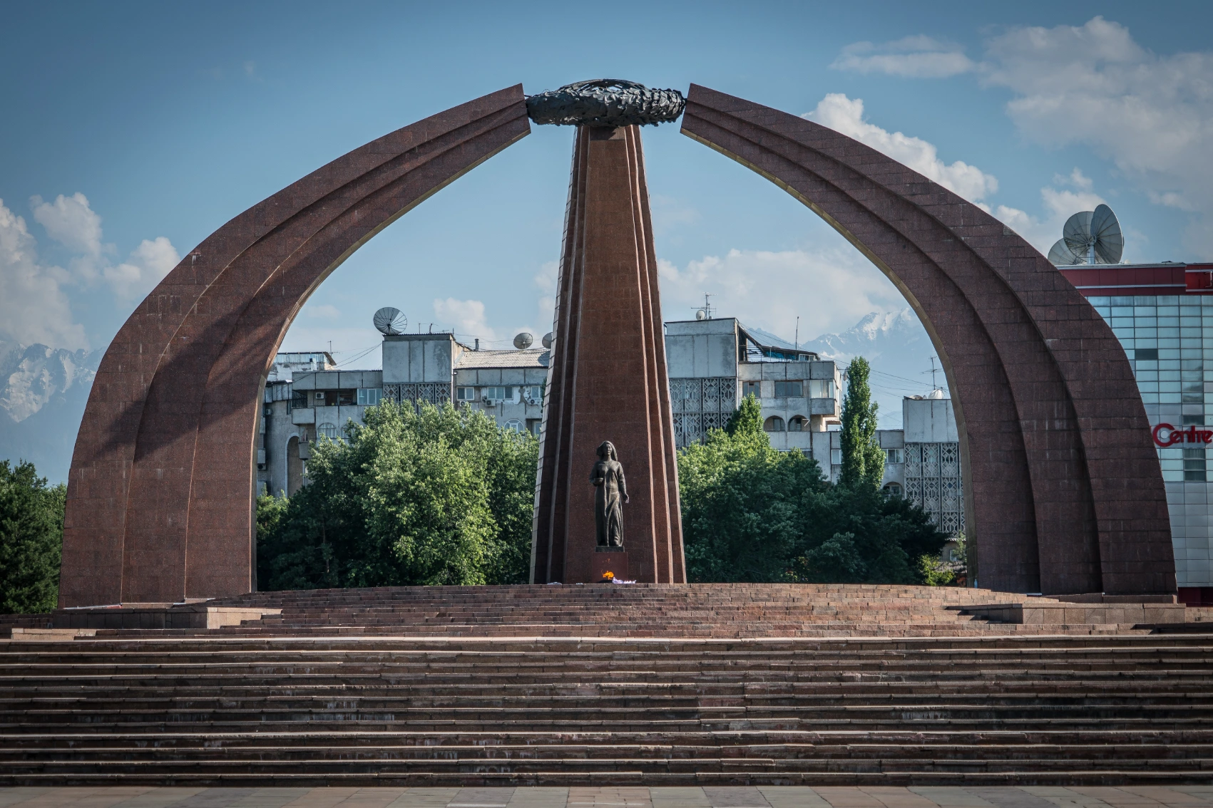 A statue in Memorial Victory Square in Bishkek, with buildings in the background
