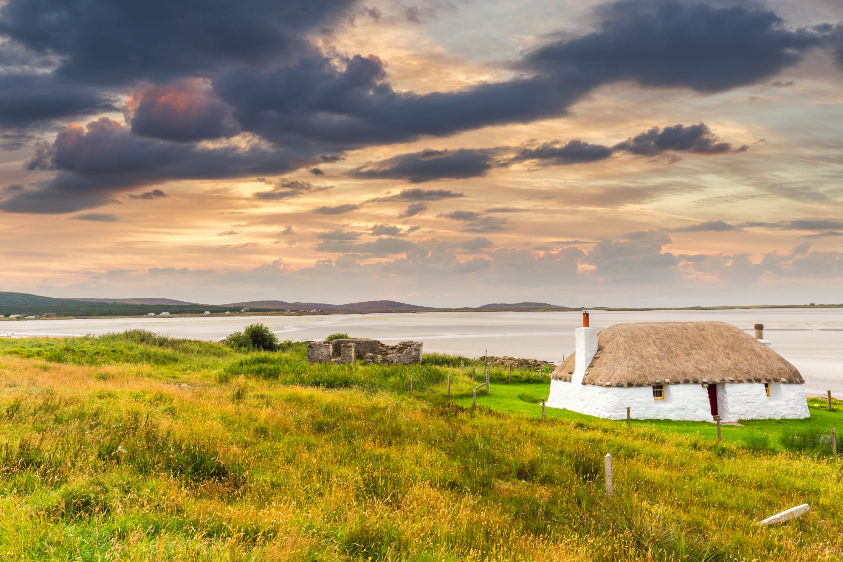 Traditional whitewashed houses near a bay in Uist, Scotland