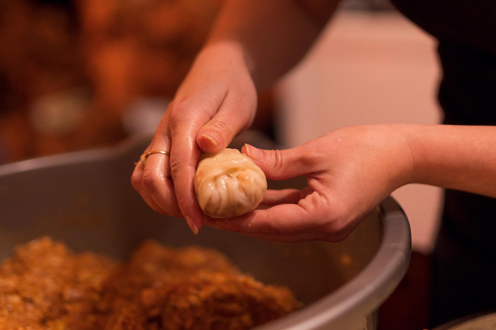 A person's hands wrap sarma before placing it in a pot