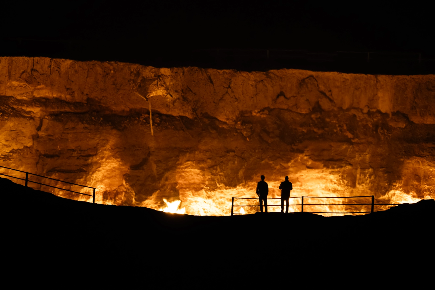 People are illuminated by the flames of the Gas Crater of Darvaza in Turkmenistan