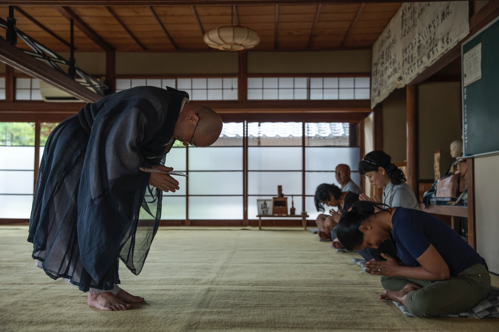 An instructor bows to a group at a meditation practice in Japan