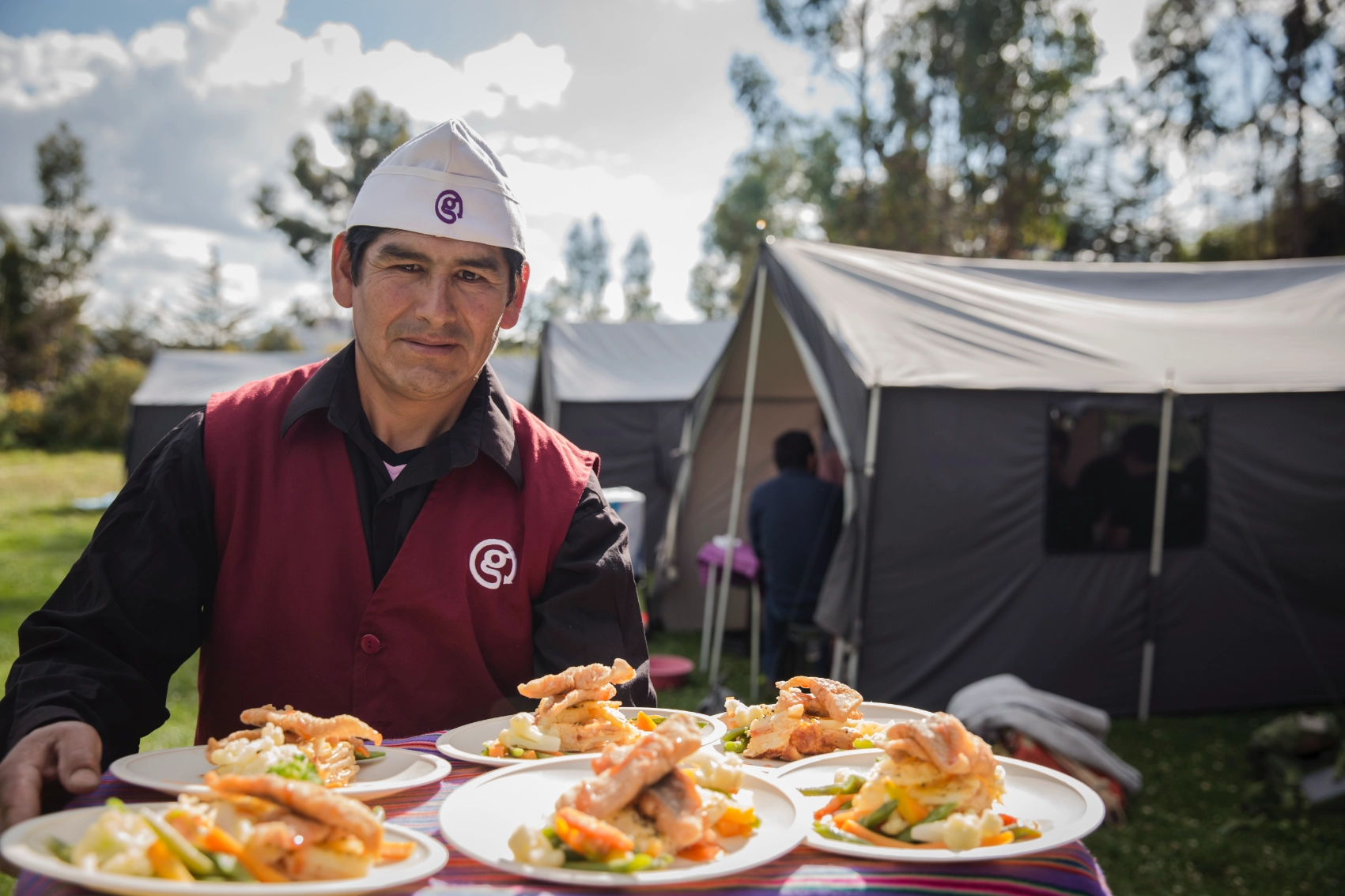 A man holds a tray of cooked dishes on the Inca Trail in Peru