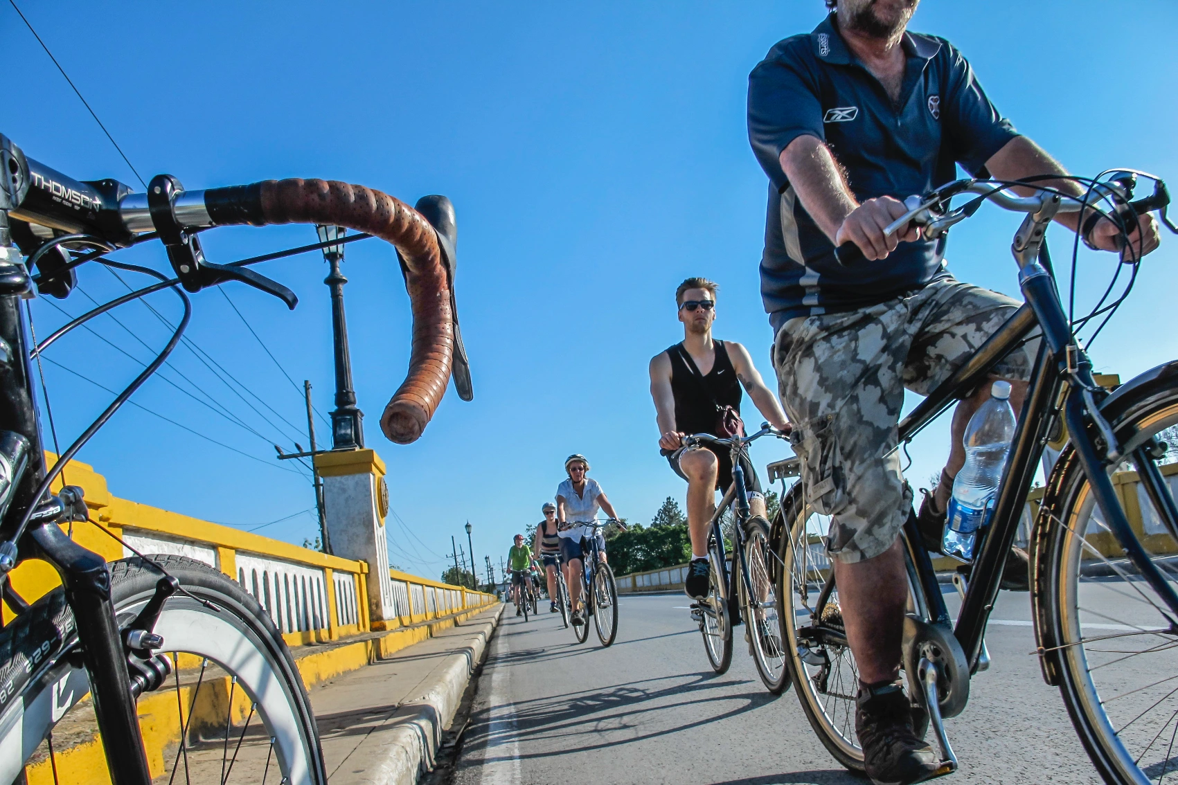 A group of travellers rides their bicycles on a road in Cuba