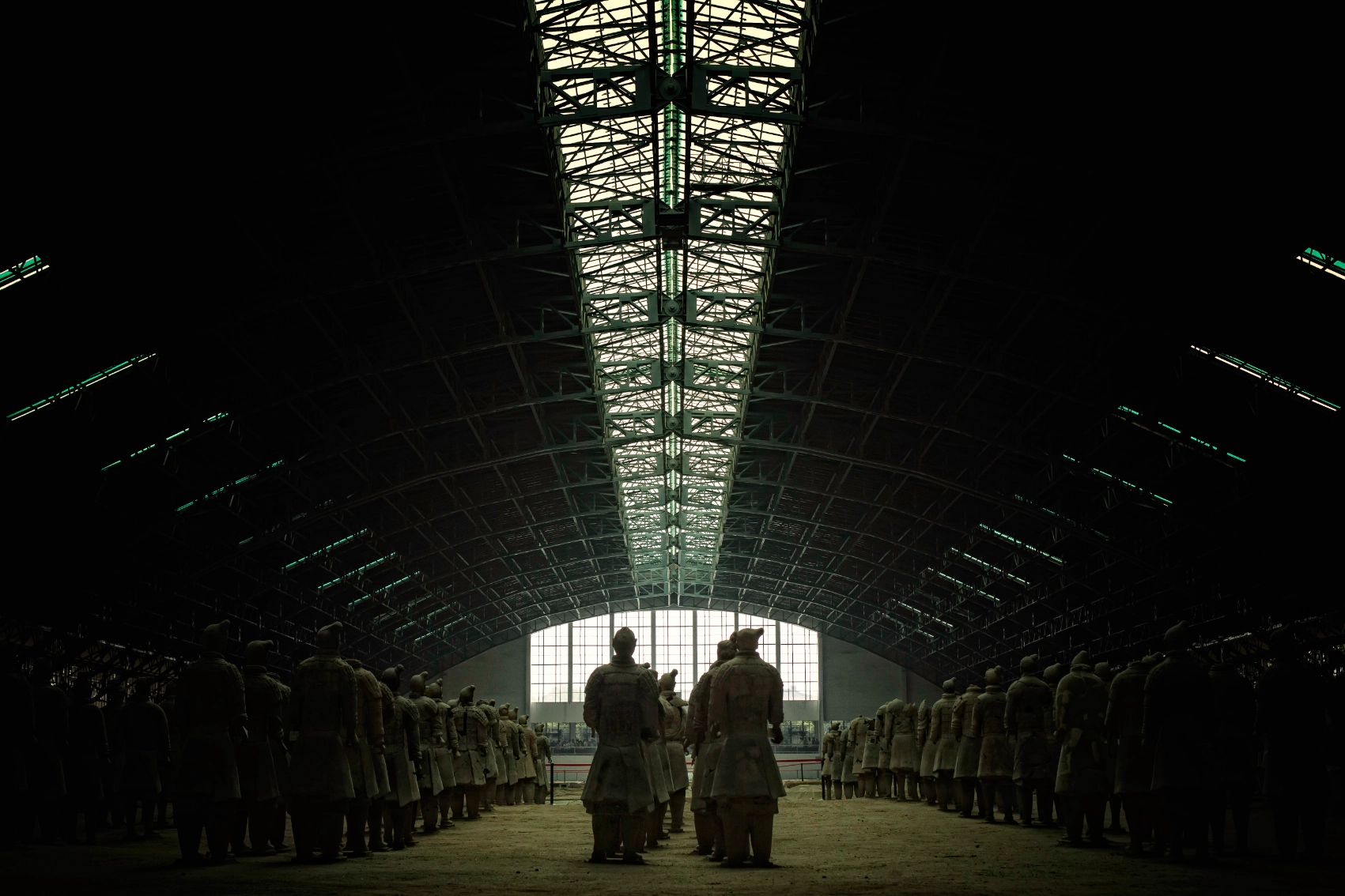 Rows of Terracotta Warriors are partially illuminated in a darkened room in Xi'an, China