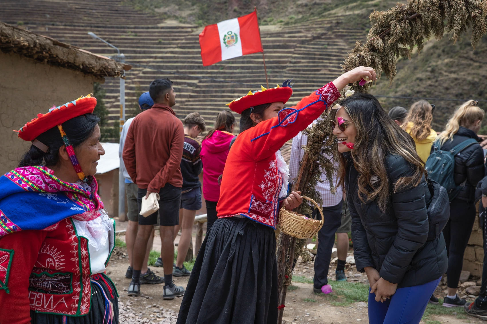 A Peruvian woman sprinkles flowers on the head of a traveller on a Classic-style G Adventures tour in Peru