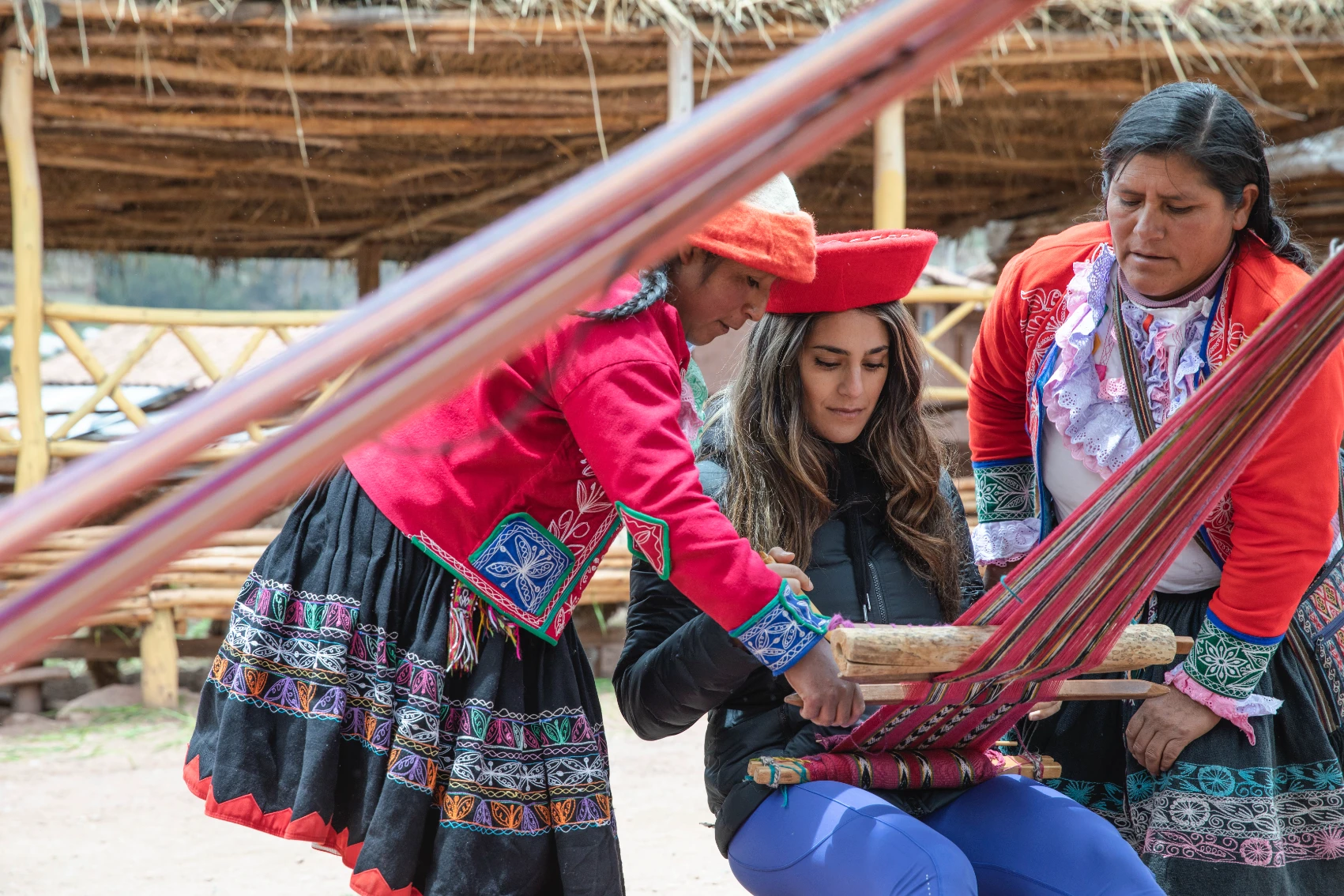 Ccaccaccollo Women’s Weaving Co-op, Peru Peruvian women instruct a traveller at a loom