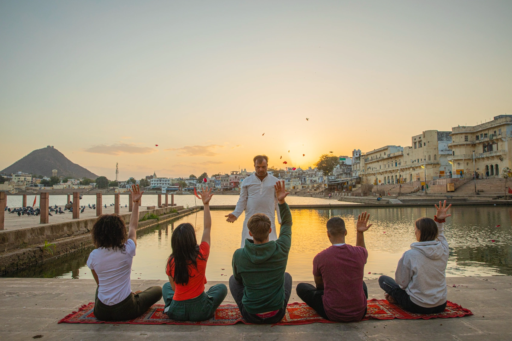 A group of travellers throws flower petals in the air in India