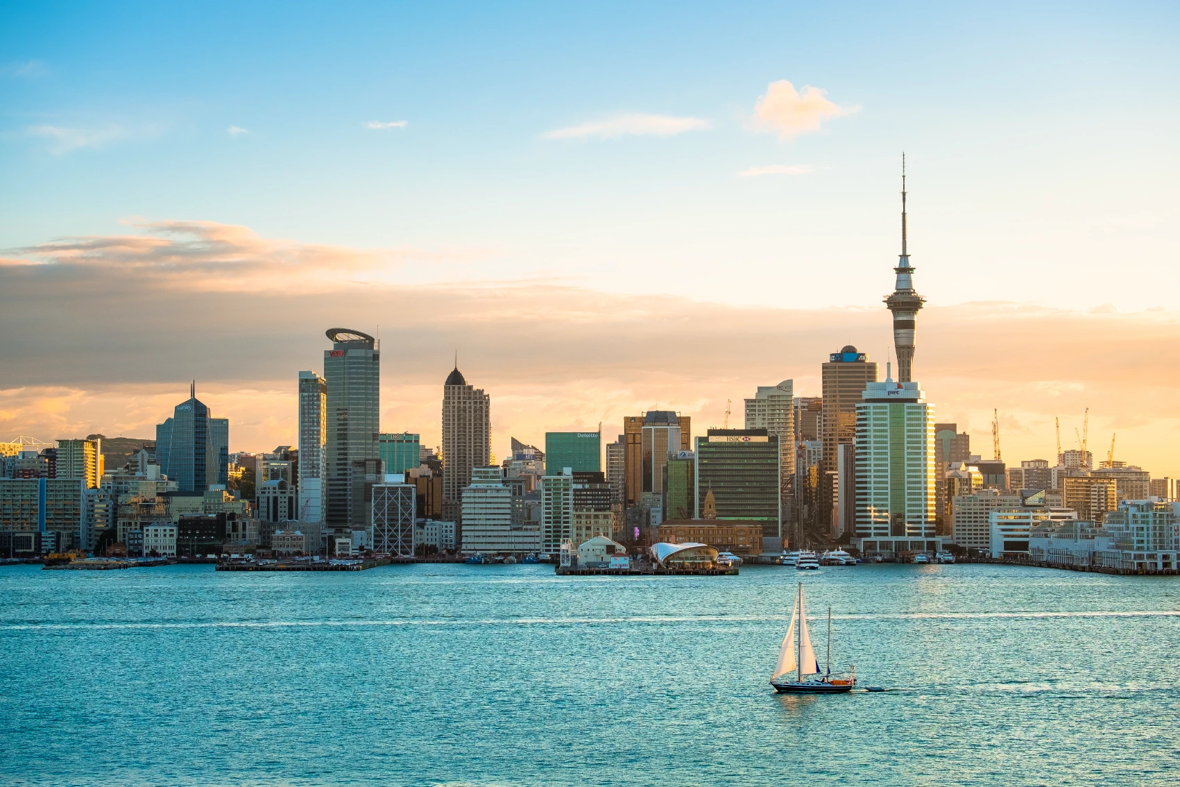 Panoramic view of the cityscape of Auckland, New Zealand, with a boat on the water