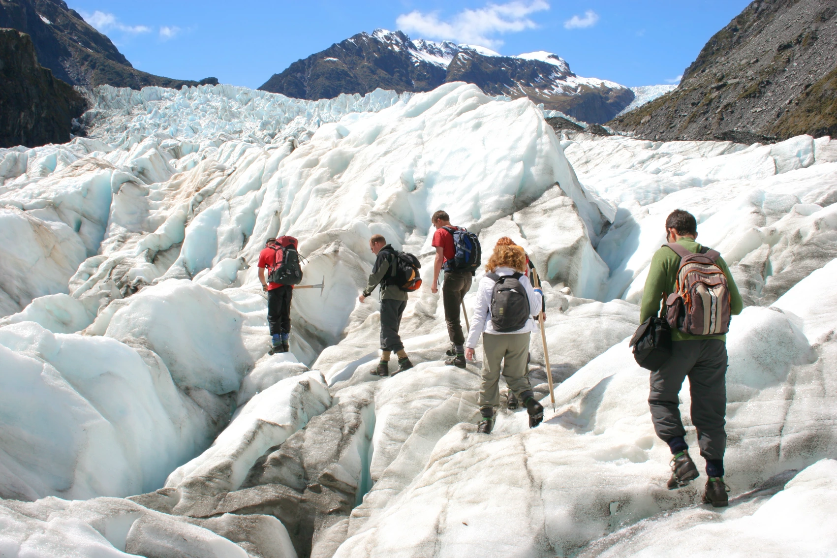 A group of hikers treks on a glacier in New Zealand