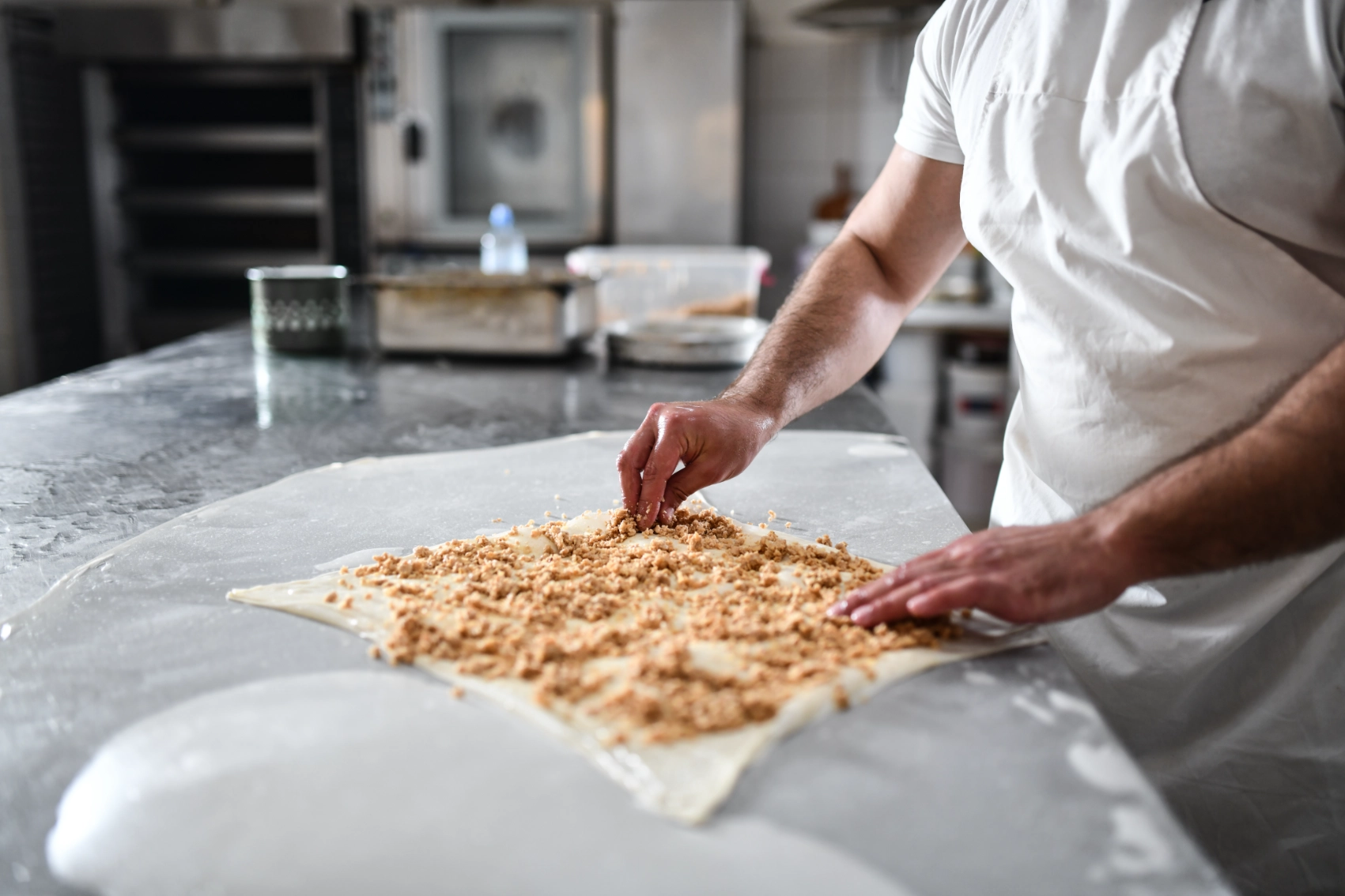 A person adds meat to a pastry to make borek in a bakery in North Macedonia