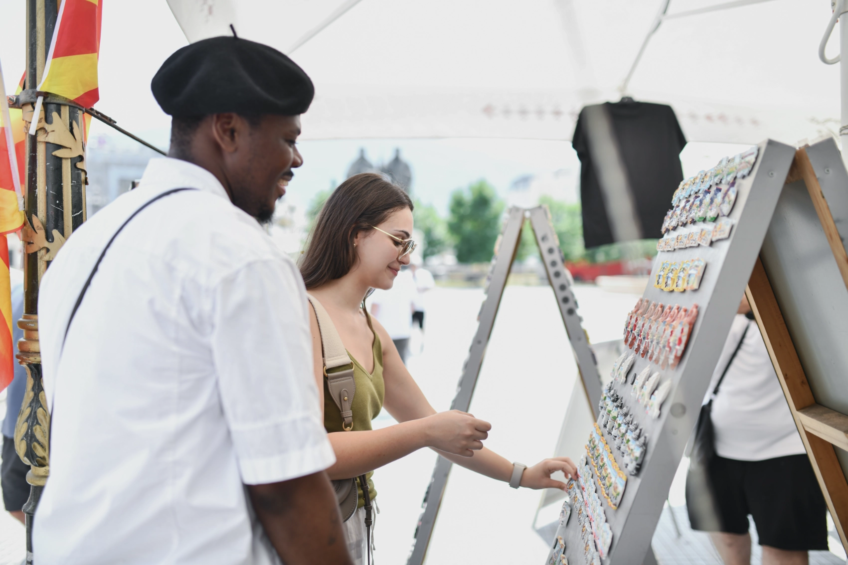 Two travellers look at magnets at a souvenir stand in the Old Bazaar in Skopje, North Macedonia