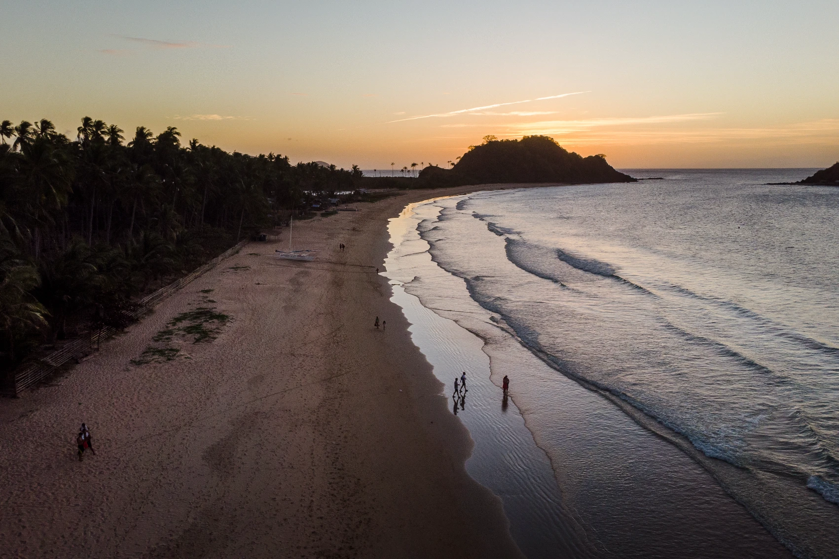 Elevated view of people walking on Nacpan Beach at dusk in the Philippines