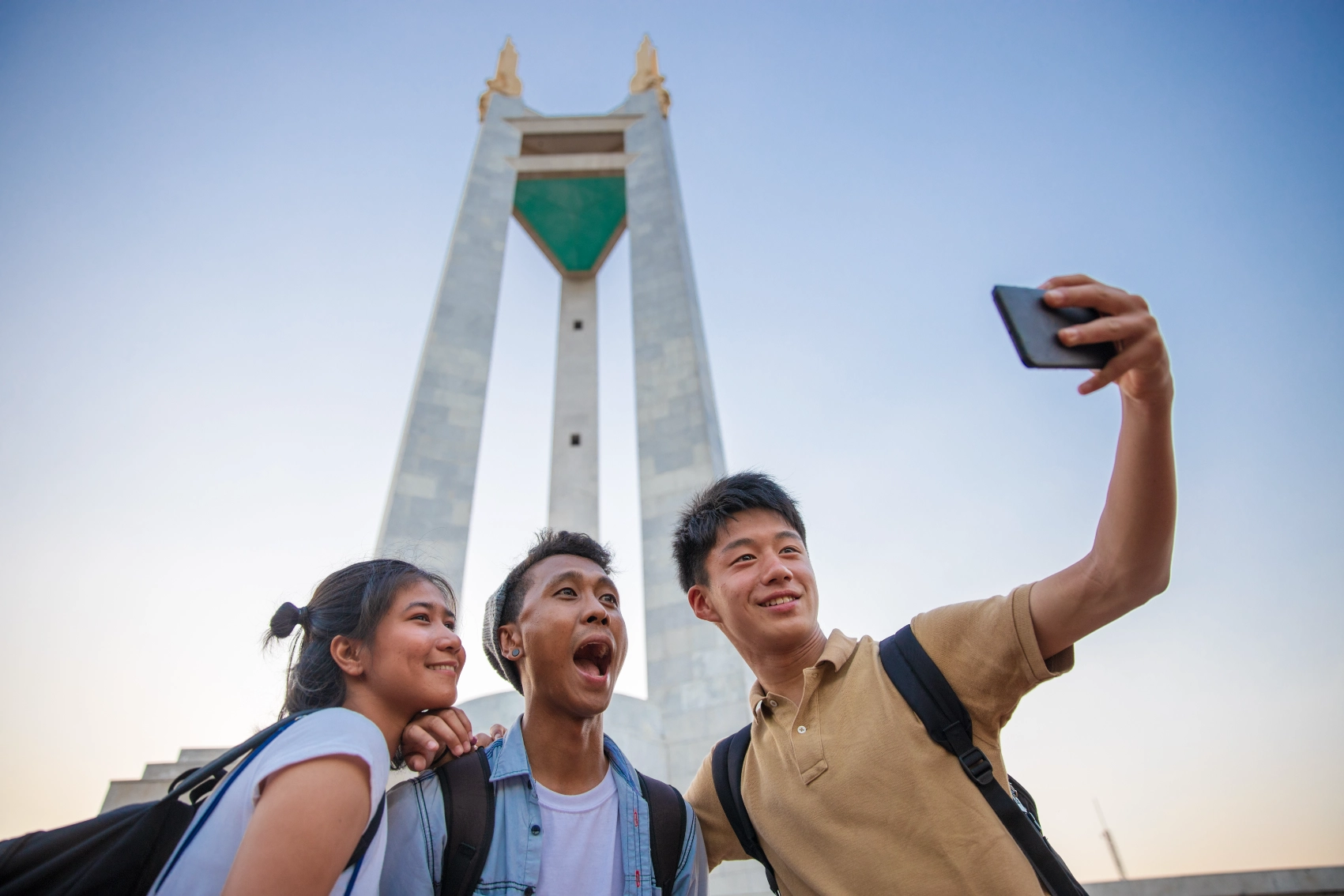 Friends take a selfie in front of a monument in Manila, Philippines