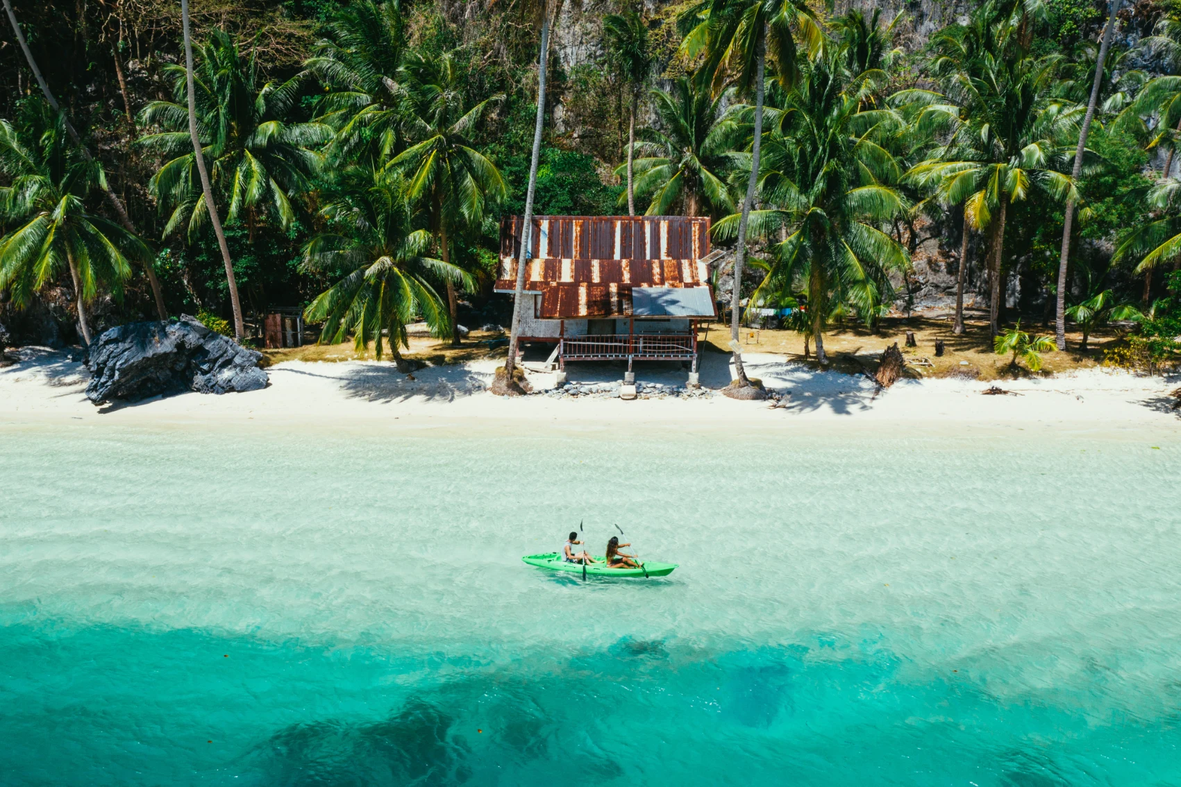 Kayaking in the Philippines Aerial view of a couple kayaking near a beach in the Philippines