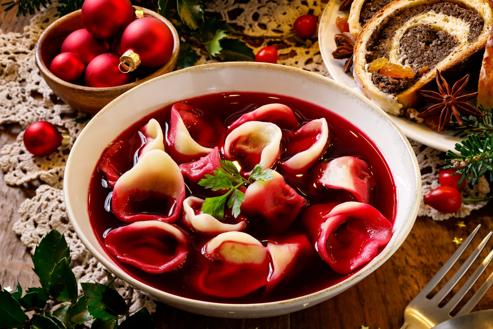 A bowl of barszcz soup surrounded by Christmas decorations in Poland