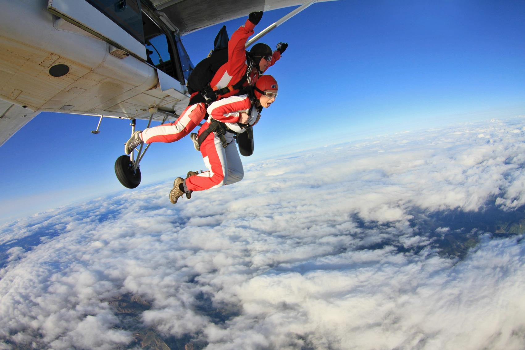 A traveller is attached to an instructor on a tandem skydiving trip in Queenstown, New Zealand